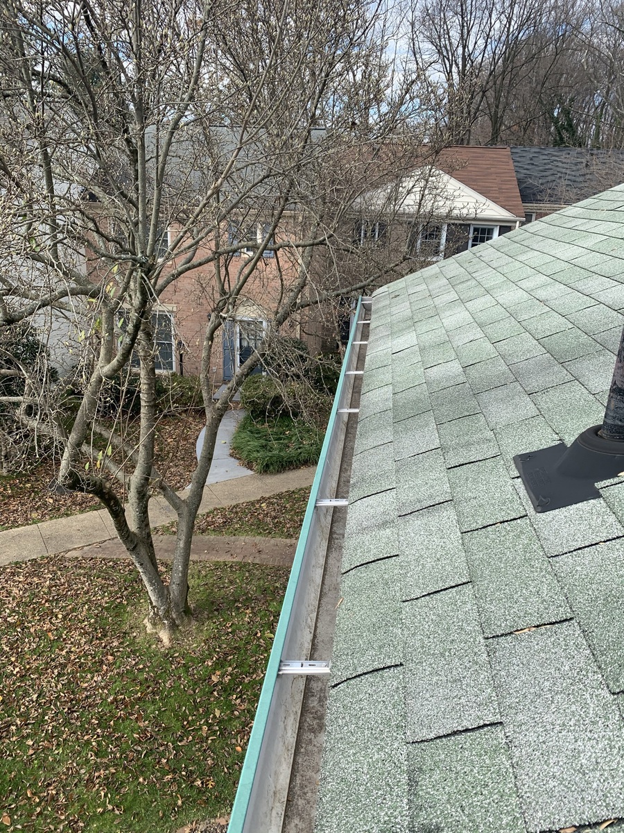 Clean gutters under a green shingle roof.