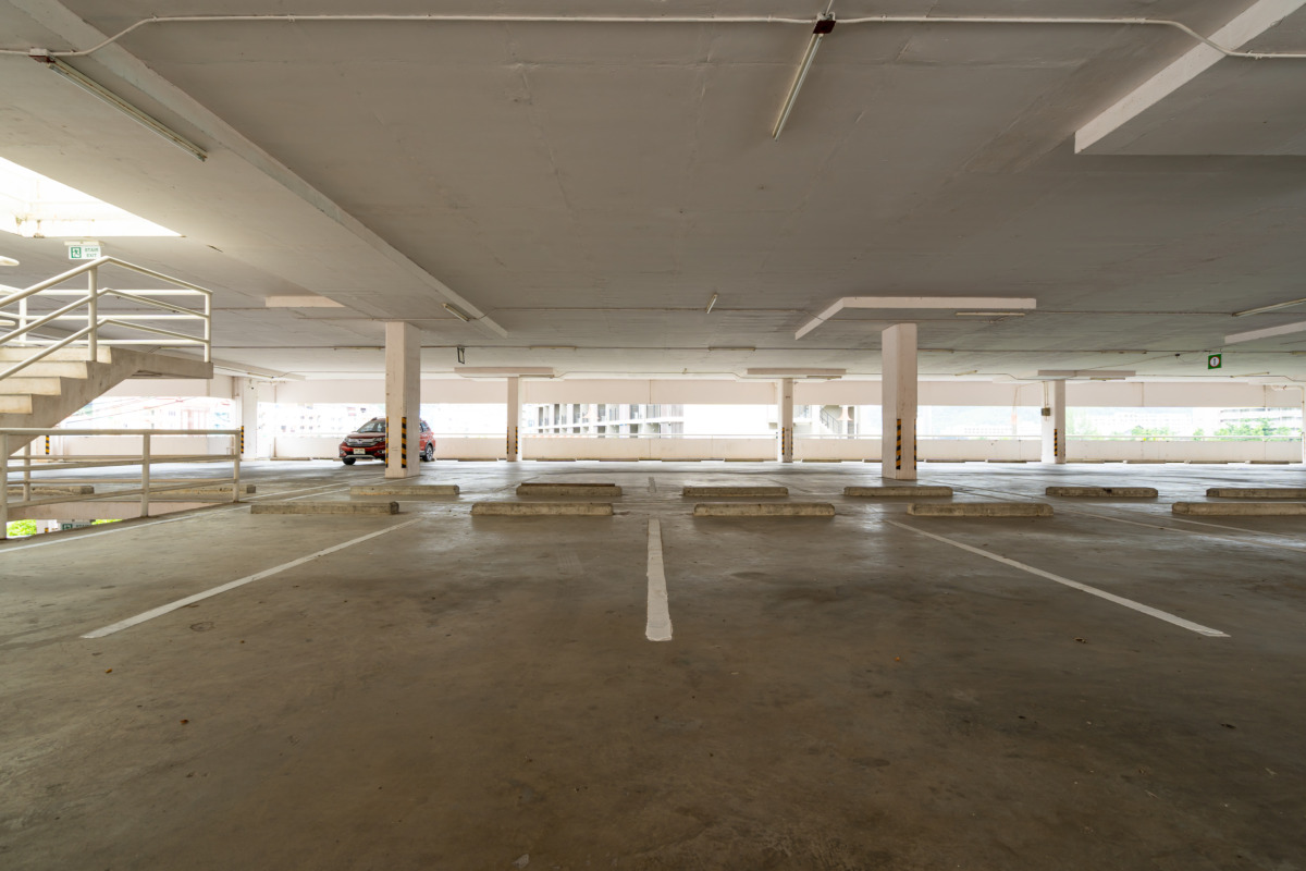 nearly empty parking garage with a concrete floor and a single parked car